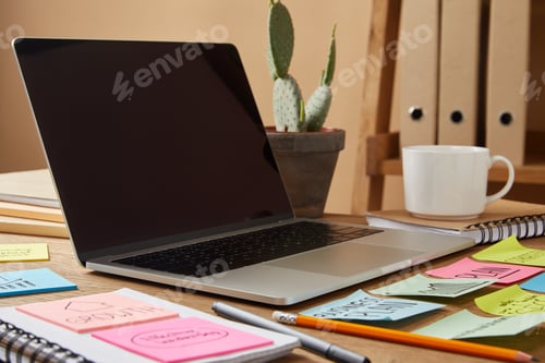 Preview: laptop with blank screen and paper stickers and cactus on tabletop