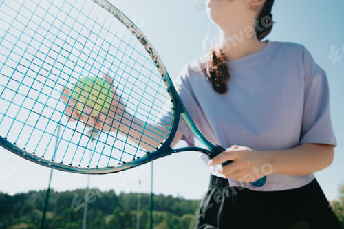 Preview: Close up image tennis player woman serving to start a new game, racket in front with tennis ball.