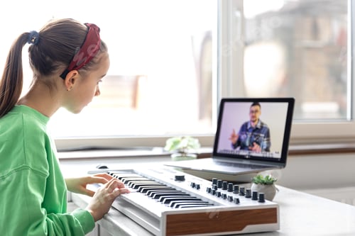Preview: A girl learns to play the piano with a teacher online, remote learning music.