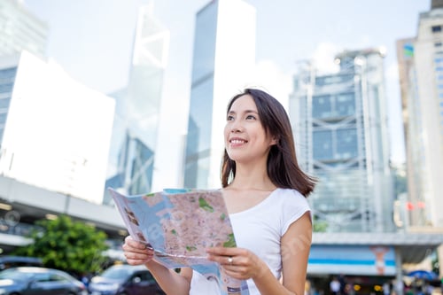 Preview: Woman holding a city map in Hong Kong city