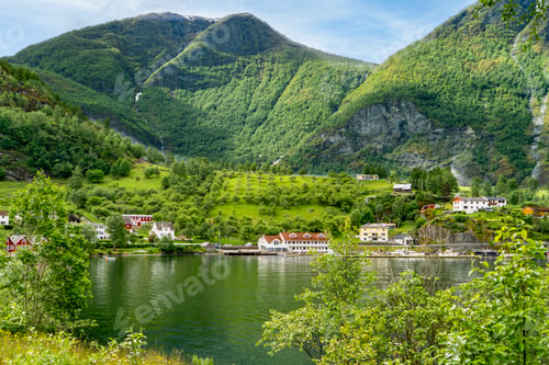 Preview: Tranquil Flam fjord landscape with charming village and imposing peaks.