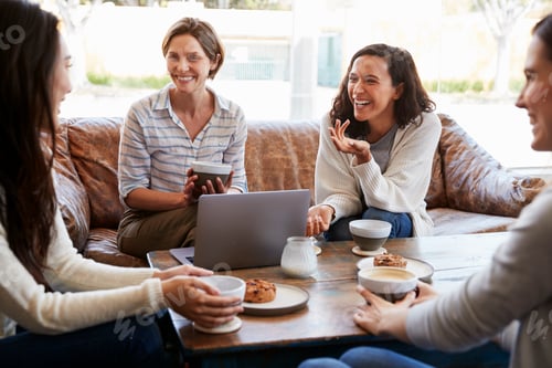 Preview: Four female friends talking over coffee at a coffee shop