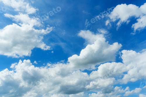 Preview: White fluffy clouds in blue sky on sunny day