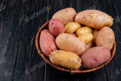 Preview: side view of potatoes in basket on wooden background with copy space