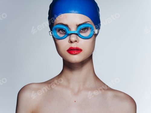 Preview: Woman with swimming goggles and blue cap cropped view