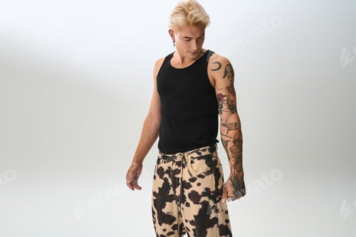 Preview: Stylish young man showcasing modern fashion with confidence in a minimalist setting