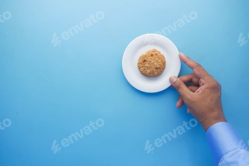 Preview: hand pick cookies from a plate , top view