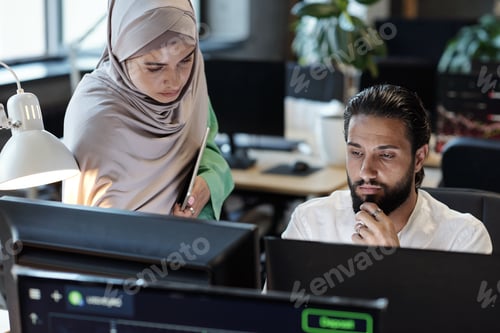 Preview: Young Muslim businessman and businesswoman working in front of computer
