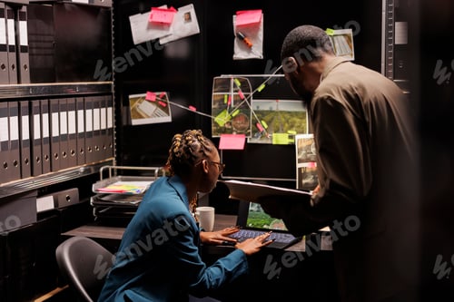 Preview: Detectives analyzing case file and searching information on laptop