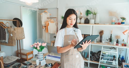 Preview: Small business owners are preparing a small shop and checking through a tablet and checking orders.
