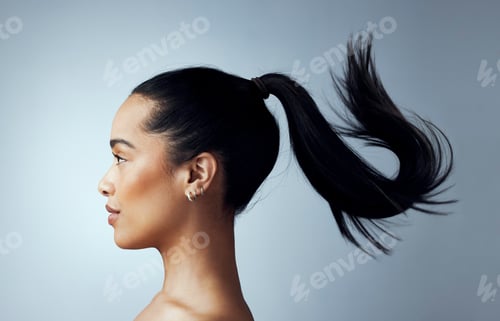 Preview: Studio shot of an attractive young woman posing against a grey background