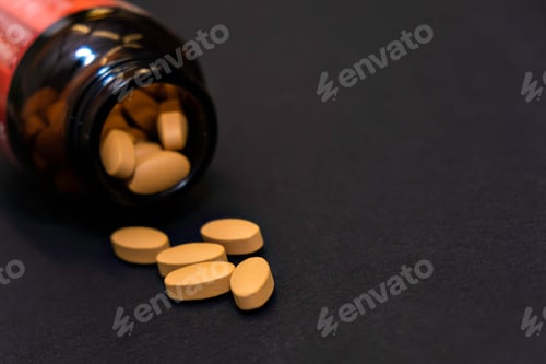 Preview: Close-up yellow capsules pill vitamins tablet and jar bottle supplements on black background