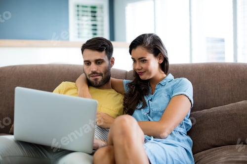 Preview: Couple Relaxing on Sofa Using Laptop Together