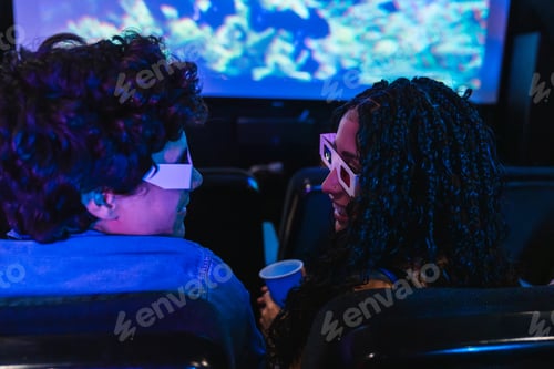 Preview: Young couple wearing 3d glasses watching movie at cinema, enjoying moment together