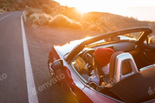 Preview: Woman traveling by car on a beautiful road during a sunset