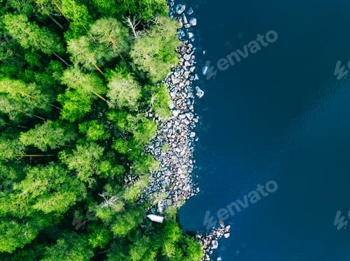 Preview: Aerial view of blue water lake with stone coast and green summer woods in Finland