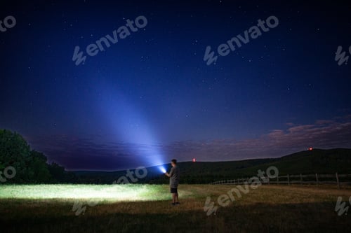 Preview: Person with flashlight under starry sky