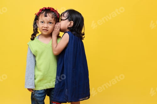 Preview: Little girl whispering secret to friend