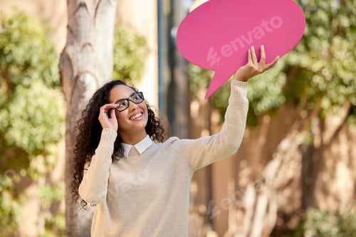 Preview: Shot of a beautiful young student holding a speech bubble above her head while standing outside