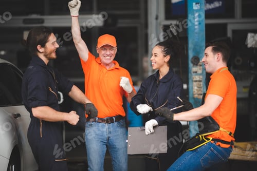 Preview: young and senior male and female car mechanics wearing uniform enjoying and celebrating
