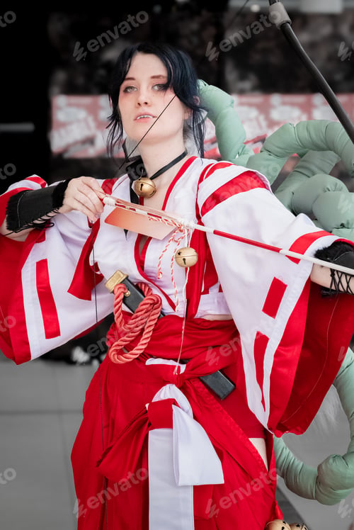 Preview: a woman wearing an outfit holding a bow and arrow while standing in front of an