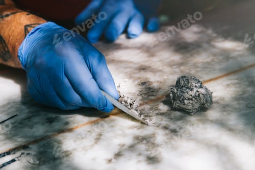 Preview: Closeup of gloved hands removing old wax with a wax comb.