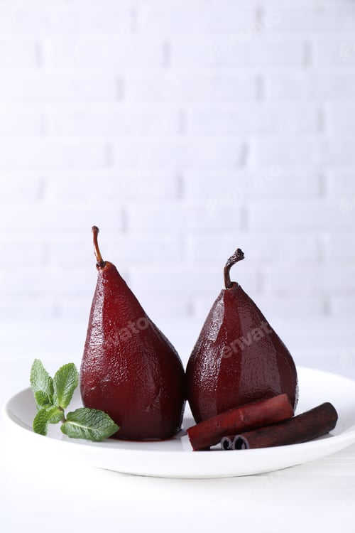 Preview: Tasty red wine poached pears with mint and cinnamon on white wooden table, closeup