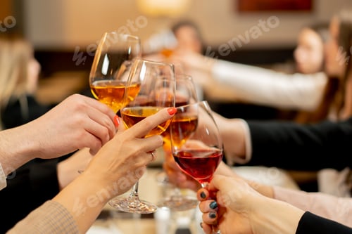 Preview: colleagues in a restaurant celebrating the conclusion new deal toasts with glasses of wine close-up