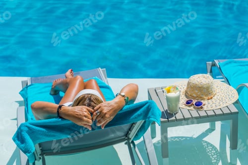 Preview: Woman relaxing by the swimming pool