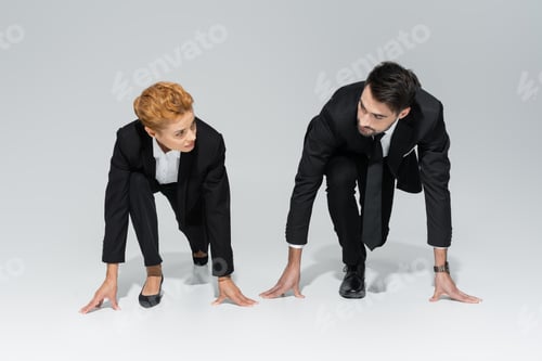 Preview: full length of business competitors in black formal wear standing in low start position and looking