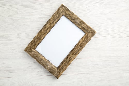 Preview: Above view of dark brown empty picture frame on white stripped background