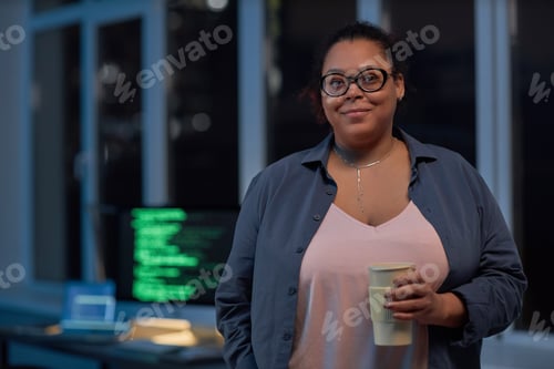 Preview: Woman with coffee standing in IT office