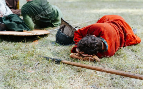 Preview: Medieval warriors resting on a halt outdoors. Viking sleeping on the grass
