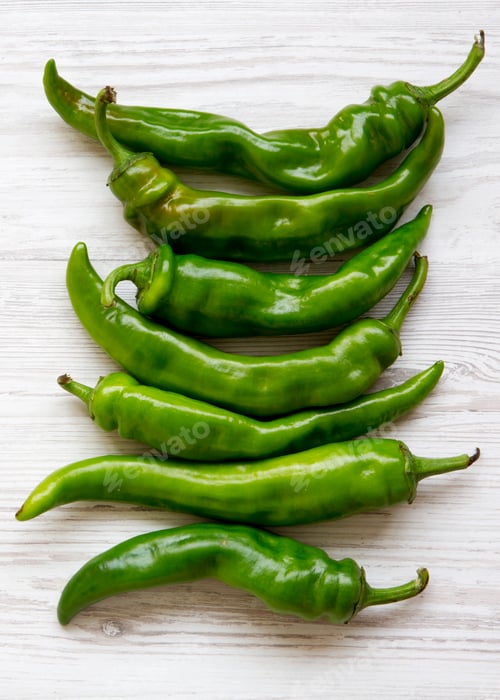 Preview: Green chili peppers on white wooden background, top view. Flat lay, from above, overhead.