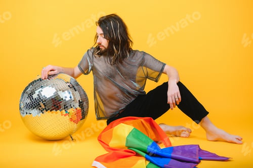 Preview: Handsome young man with pride movement LGBT Rainbow flag on shoulder against white background