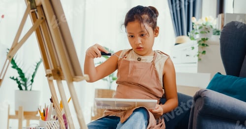 Preview: Child Paints with Palette and Easel Indoors