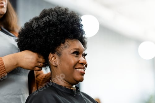 Preview: Hairstylist giving a finish touch for the customer's hairdo