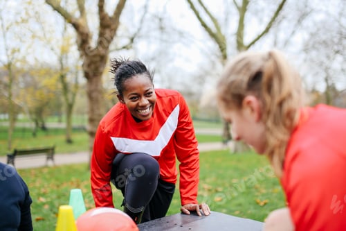 Preview: Adult female soccer players preparing to play soccer in park