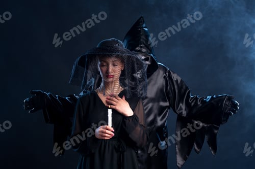 Preview: young female dressed in black holding candle on dark background grim reaper death evil funeral