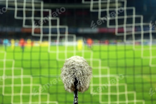 Preview: Big and furry sport microphone on a soccer field behind the goal net