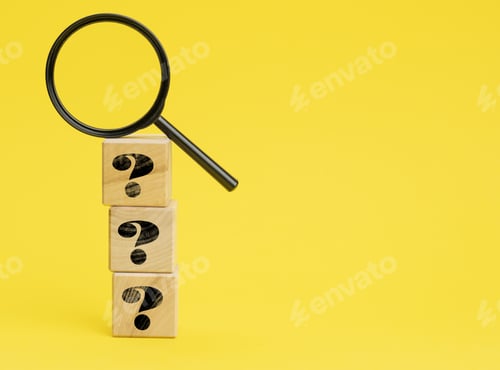 Preview: Wooden cubes with question marks and a magnifying glass on a yellow background