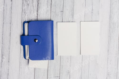 Preview: blue business card holder and white letterheads on a wooden table Copy Space