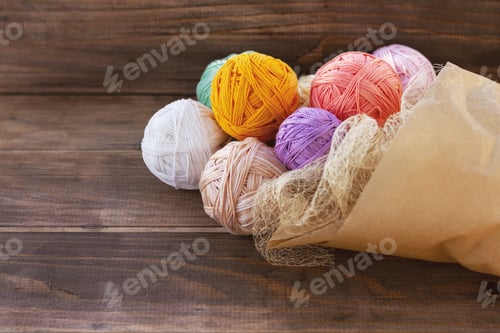 Preview: bouquet of multi-colored balls of yarn in craft packagin on wooden table
