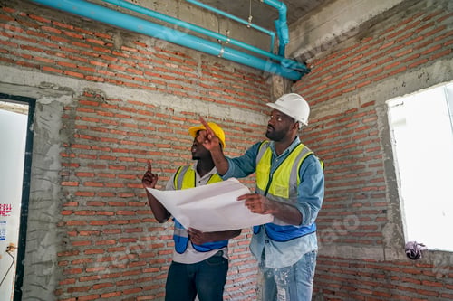 Preview: Two construction workers discussing plans in a building under renovation