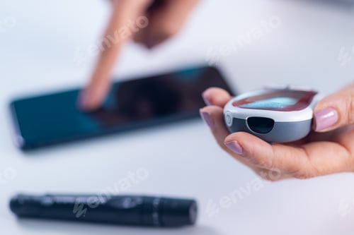 Preview: A person measures glucose levels, using a smartphone app for tracking and analyzing results,
