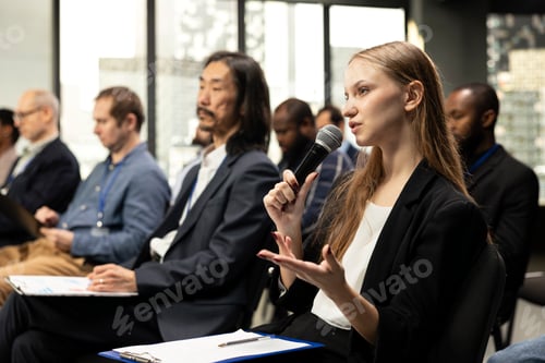 Preview: Young woman journalist reading questions from clipboard and taking notes