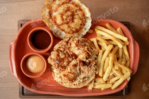 Preview: Delightful chicken sandwich served with crispy fries and dipping sauces