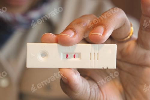 Preview: Closeup view of a Positive Medical Test Result held in Hand, showcasing the outcome clearly