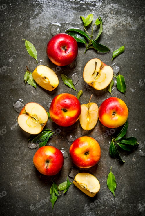 Preview: Red apples with leaves on stone background.