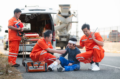 Preview: The paramedic is assisting an injured man in an emergency situation on the road.
